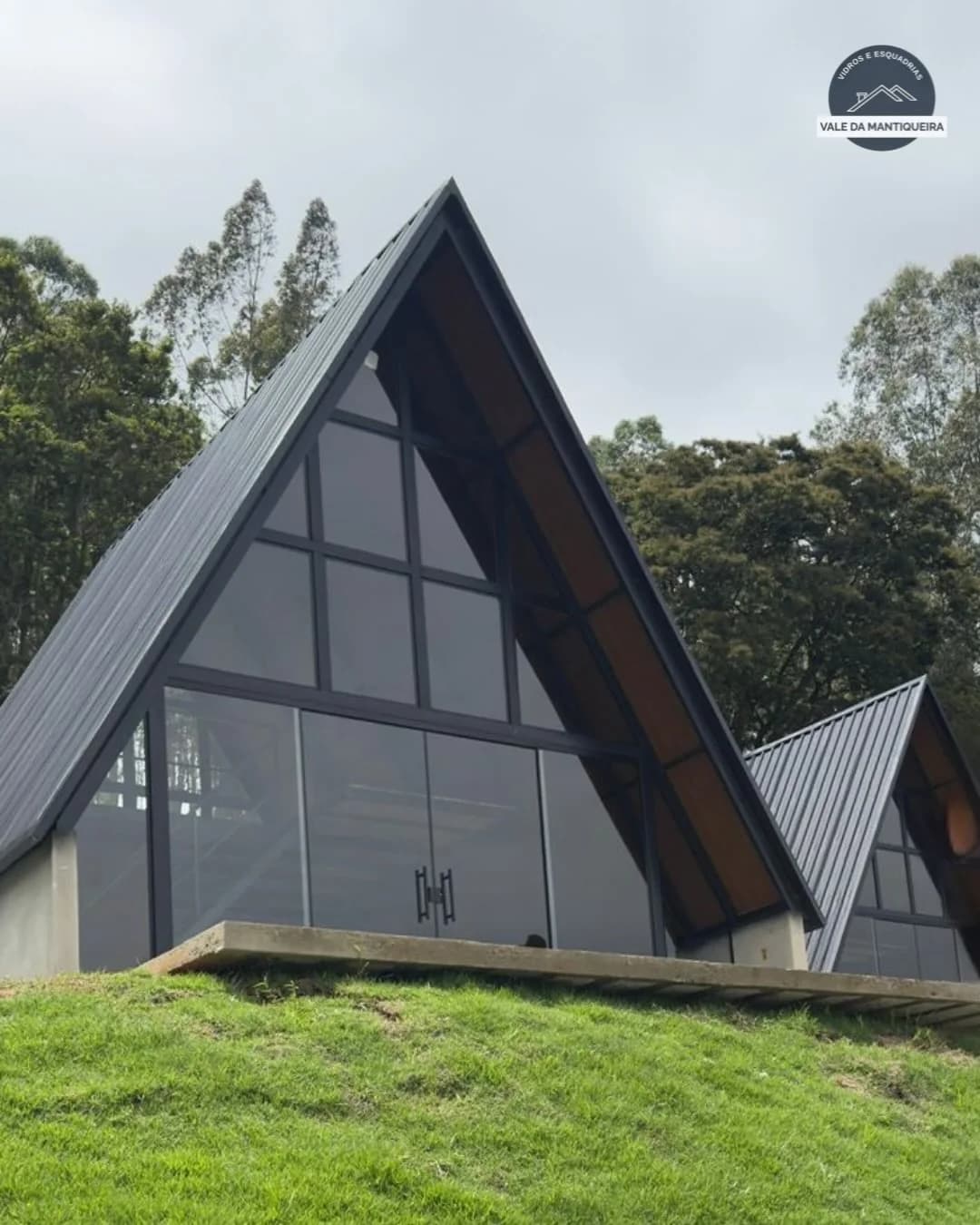 Casa com fachada triangular e grandes painéis de vidro